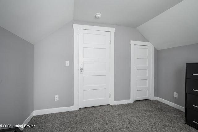 additional living space with lofted ceiling and dark colored carpet