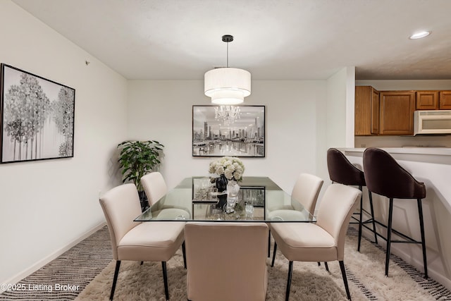 carpeted dining space featuring an inviting chandelier