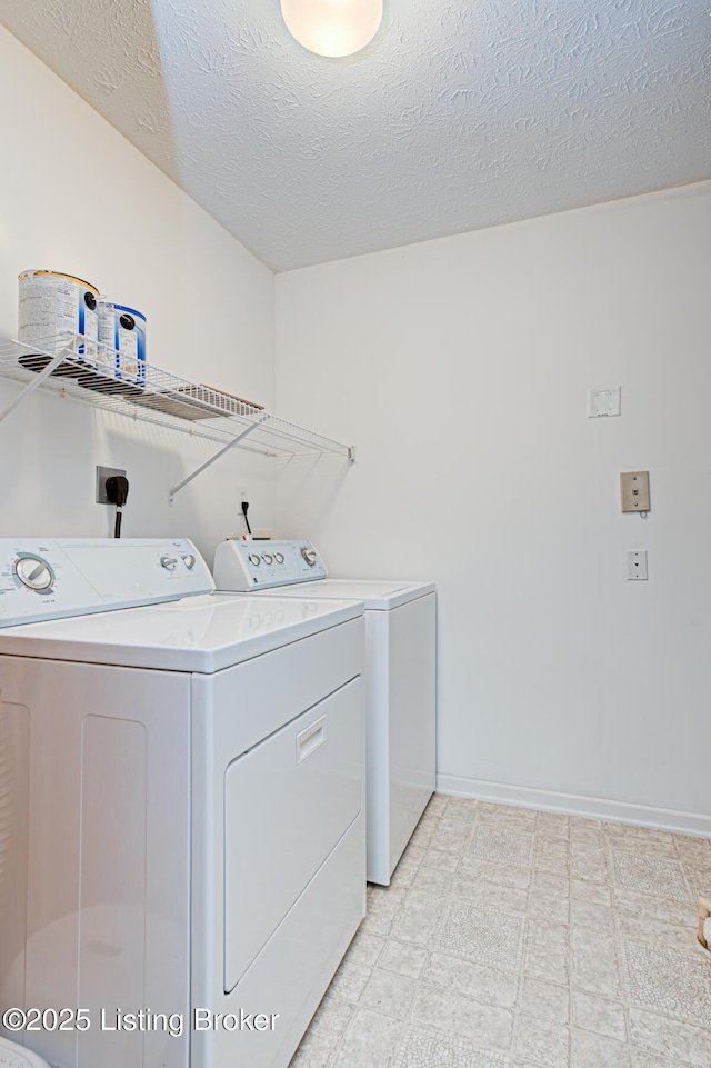 clothes washing area featuring washer and dryer and a textured ceiling