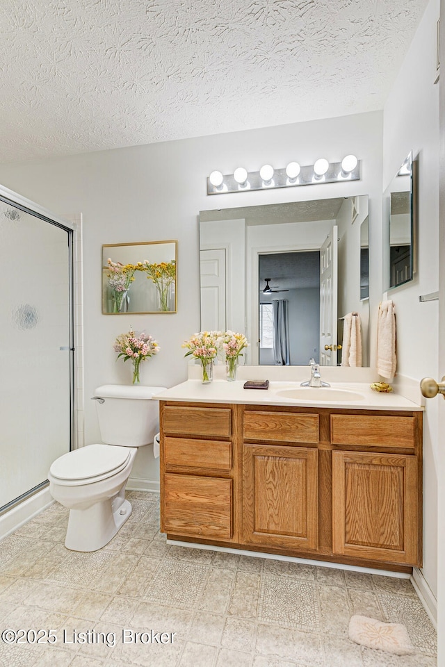 bathroom featuring vanity, toilet, a textured ceiling, and a shower with shower door