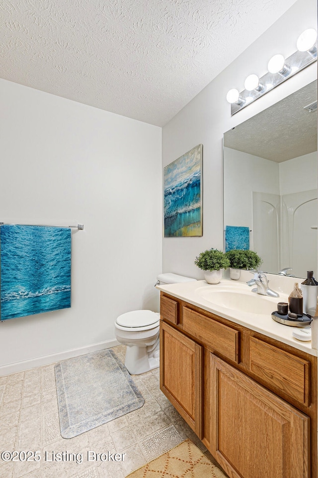 bathroom with vanity, a textured ceiling, and toilet