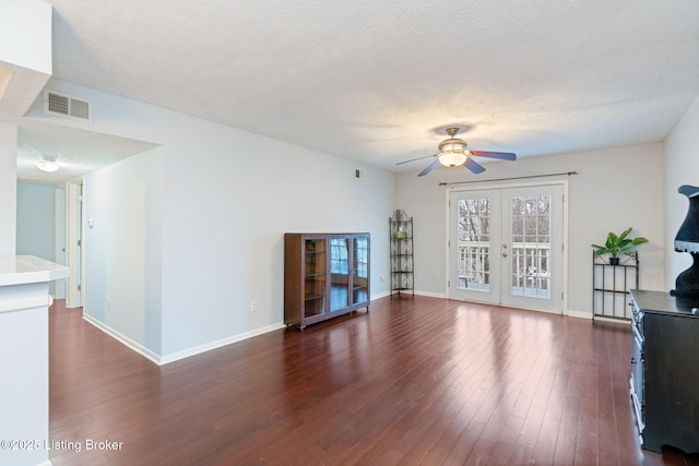 living room with french doors, ceiling fan, dark hardwood / wood-style flooring, and a textured ceiling