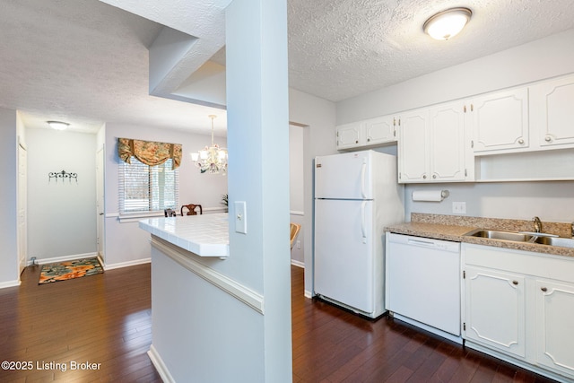 kitchen featuring dark hardwood / wood-style flooring, sink, white cabinets, and white appliances