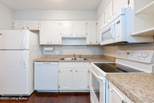 kitchen with dark wood-type flooring, white appliances, sink, and white cabinets