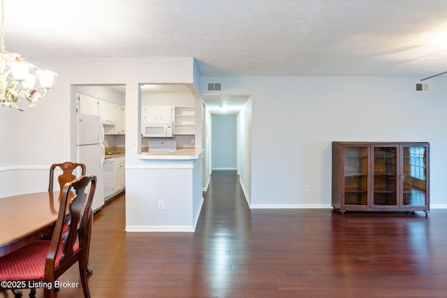 interior space with an inviting chandelier, a textured ceiling, and dark hardwood / wood-style flooring