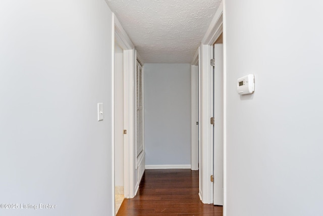 hallway featuring dark hardwood / wood-style floors and a textured ceiling