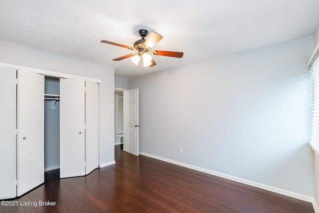 unfurnished bedroom with ceiling fan, dark hardwood / wood-style flooring, a closet, and a textured ceiling