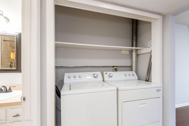 washroom with washing machine and clothes dryer and sink