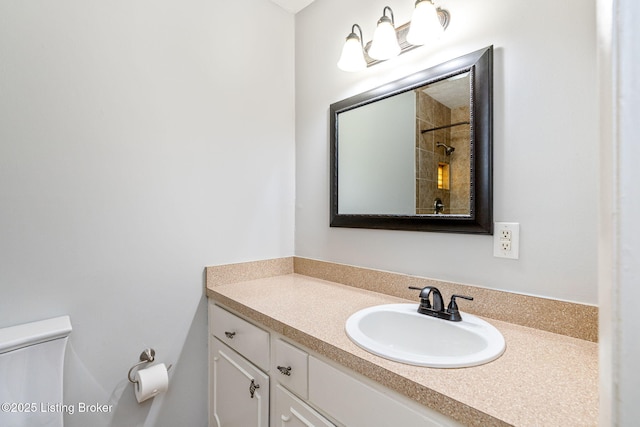 bathroom with vanity, a shower, and toilet