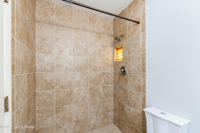 bathroom with toilet and tiled shower