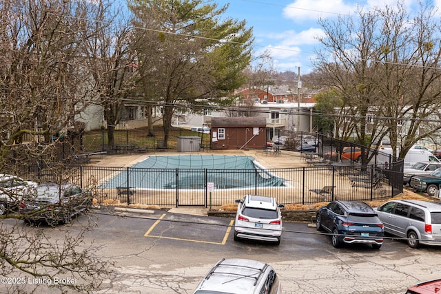 view of pool with a storage shed and a patio