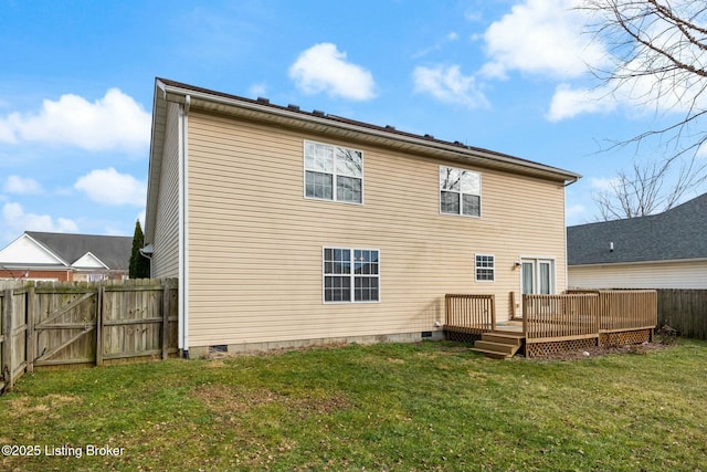 back of property featuring a deck and a lawn