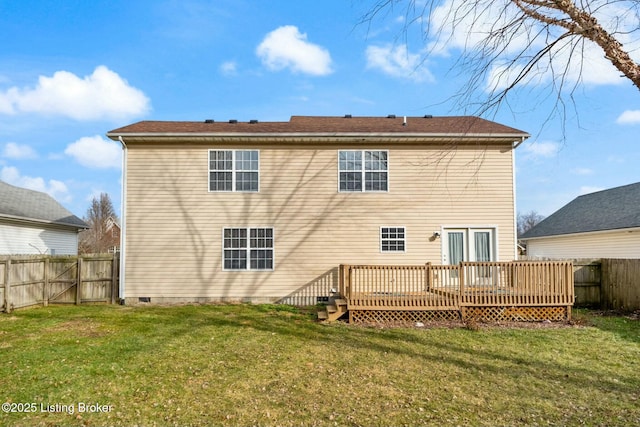 back of house featuring a lawn and a wooden deck