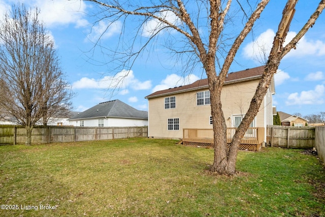 back of property with a yard and a wooden deck