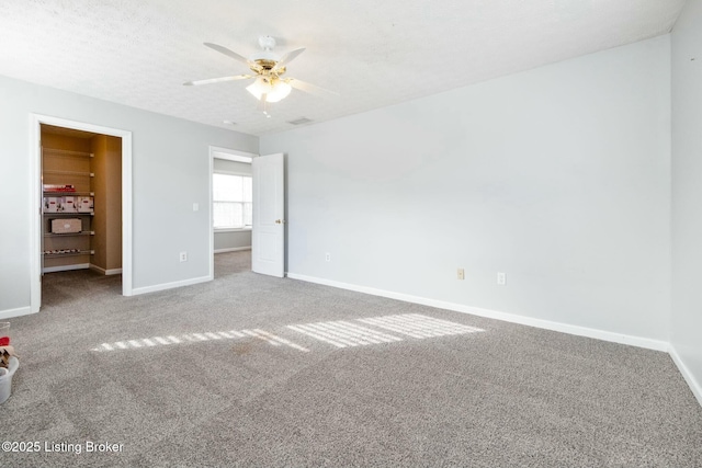 unfurnished bedroom with ceiling fan, carpet floors, and a textured ceiling