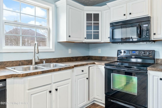 kitchen featuring sink, white cabinetry, and black appliances