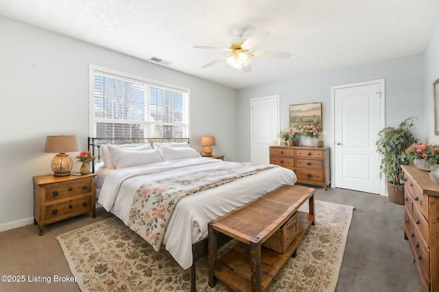 carpeted bedroom with ceiling fan and a textured ceiling