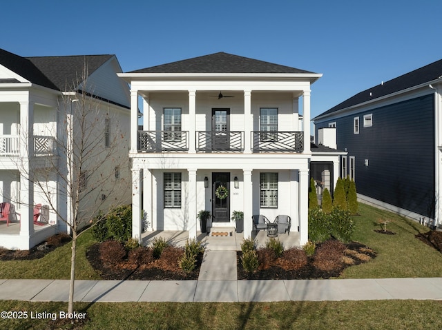 view of front facade featuring a balcony, a porch, and a front lawn