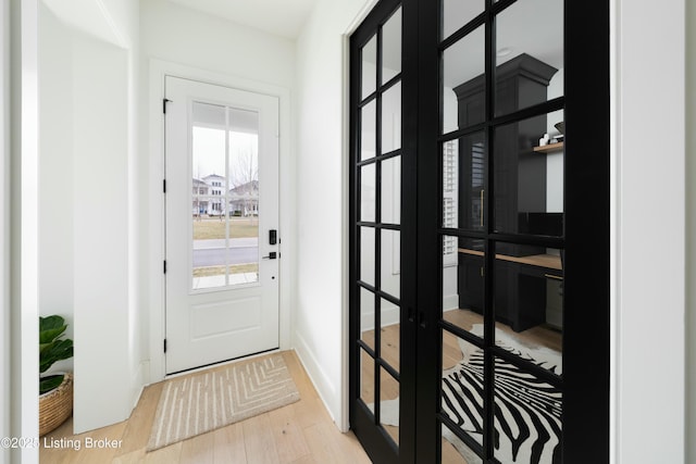 entryway with light hardwood / wood-style flooring and french doors