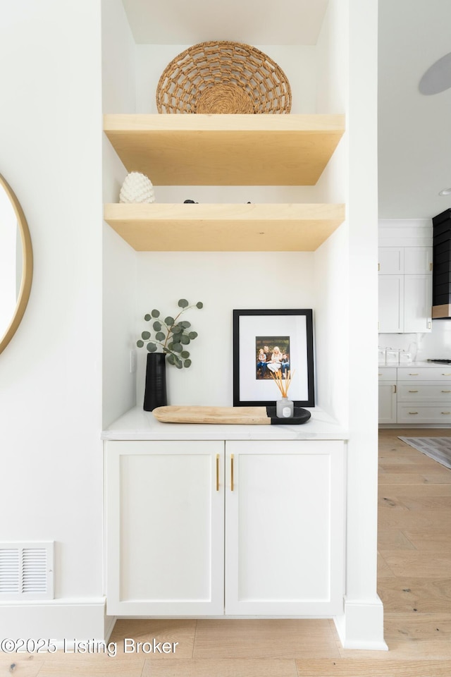 details with hardwood / wood-style flooring and tasteful backsplash