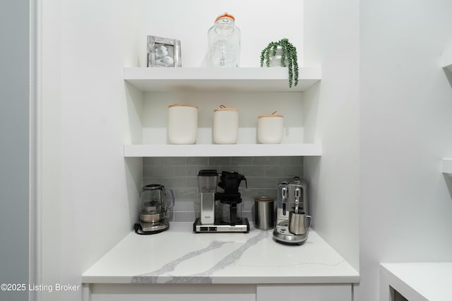 bar with light stone counters and decorative backsplash