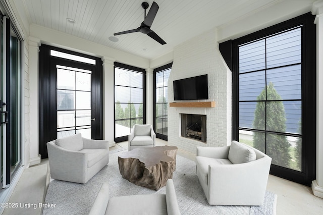 living room featuring wood ceiling, a fireplace, ornamental molding, and ceiling fan