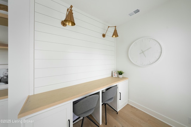 mudroom featuring built in desk and light hardwood / wood-style flooring