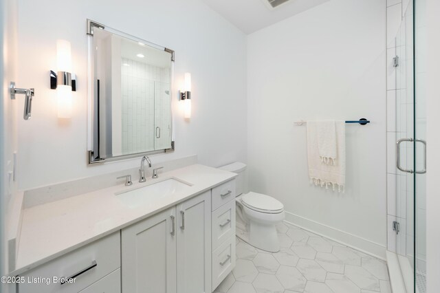 bathroom with vanity, an enclosed shower, and toilet