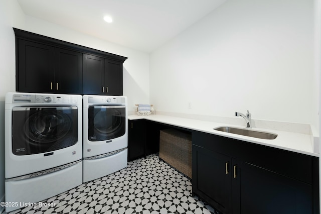 washroom with cabinets, sink, and washer and dryer