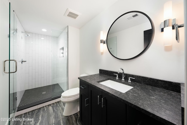 bathroom with vanity, toilet, and a shower with shower door