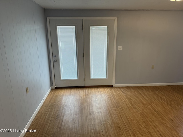 unfurnished room featuring french doors and light wood-type flooring