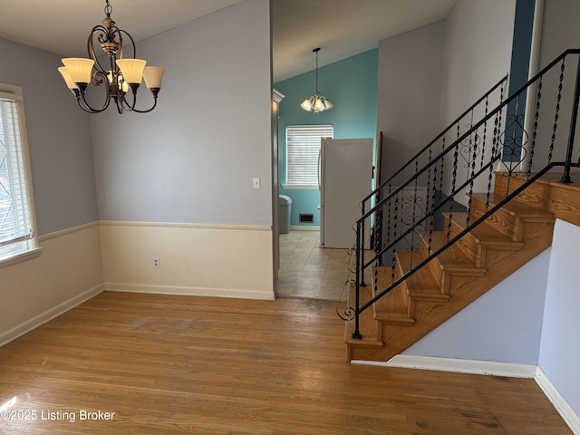 interior space featuring an inviting chandelier, hardwood / wood-style floors, and lofted ceiling