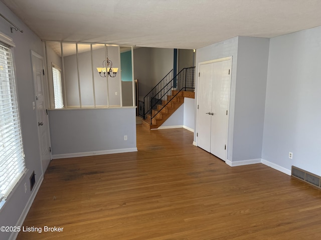 spare room featuring hardwood / wood-style floors and a chandelier