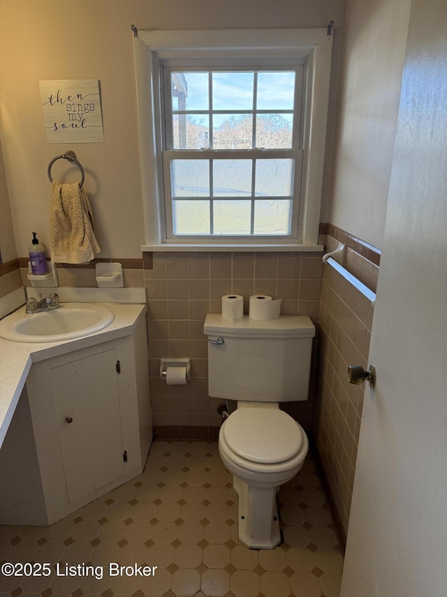 bathroom with tile walls, vanity, and toilet