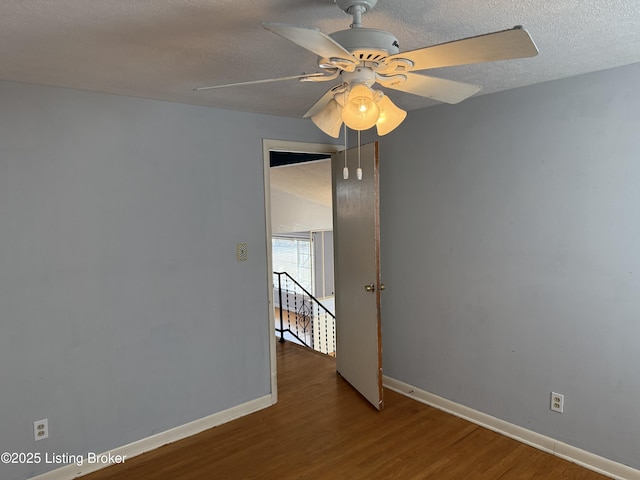 empty room featuring ceiling fan, hardwood / wood-style floors, and a textured ceiling