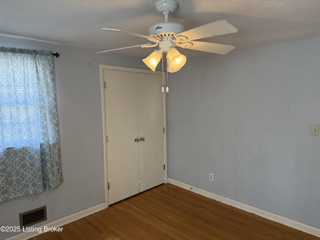 unfurnished bedroom featuring ceiling fan, wood-type flooring, a closet, and a textured ceiling