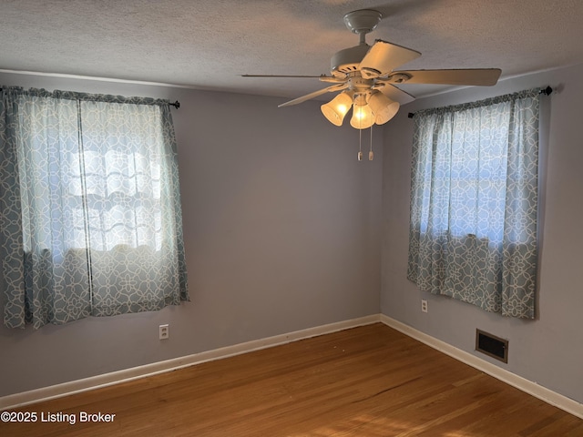 unfurnished room featuring hardwood / wood-style flooring, ceiling fan, and a textured ceiling