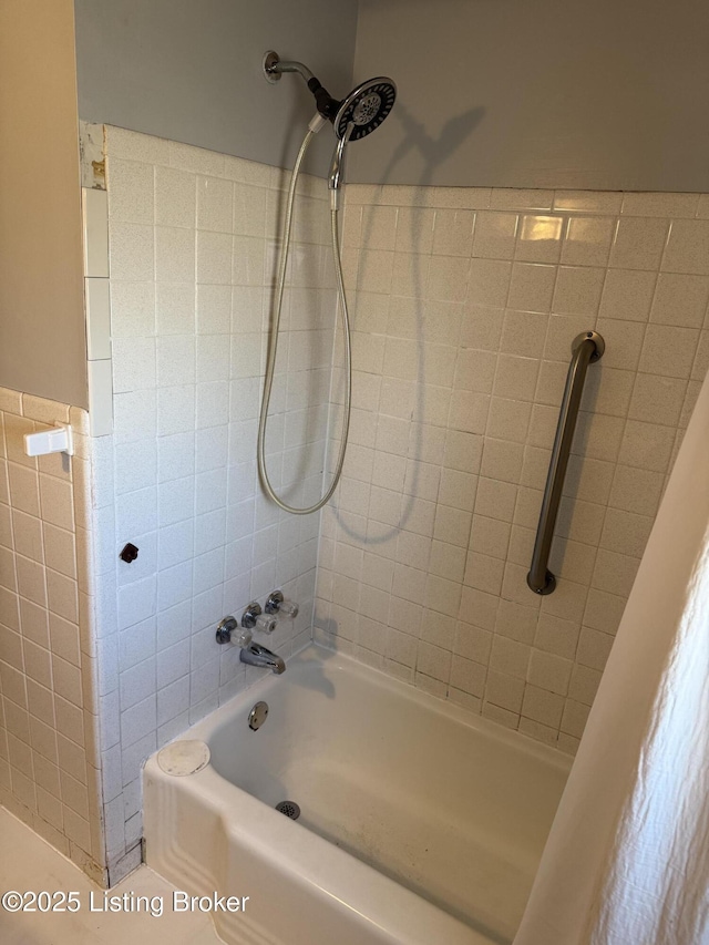 bathroom with tile walls and tiled shower / bath