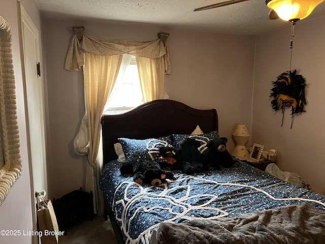 bedroom with ceiling fan and a textured ceiling