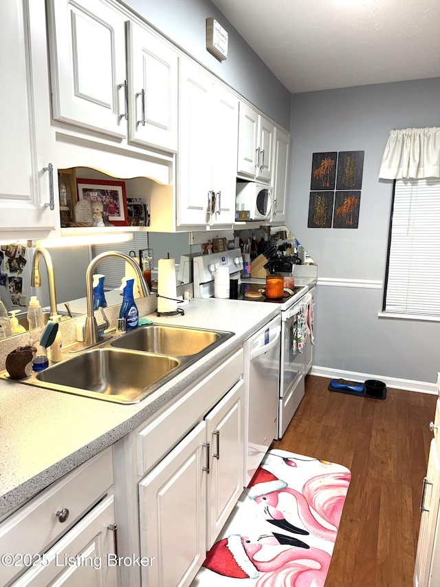 kitchen featuring range with electric cooktop, sink, white cabinets, stainless steel dishwasher, and dark wood-type flooring