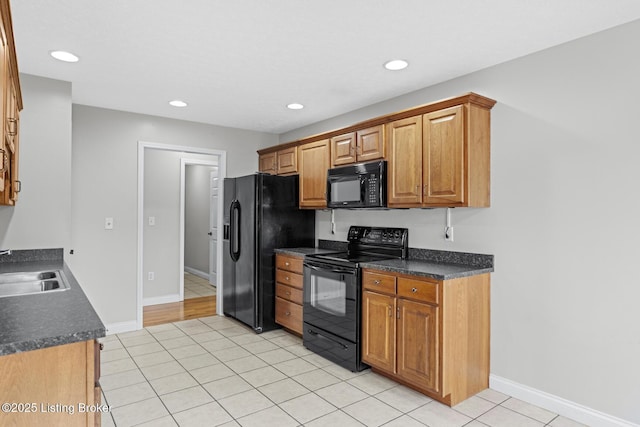 kitchen with light tile patterned floors, sink, and black appliances