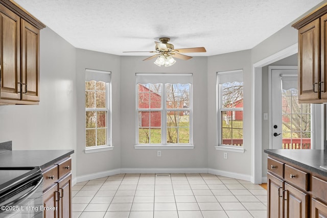 kitchen featuring ceiling fan, a healthy amount of sunlight, light tile patterned floors, and a textured ceiling