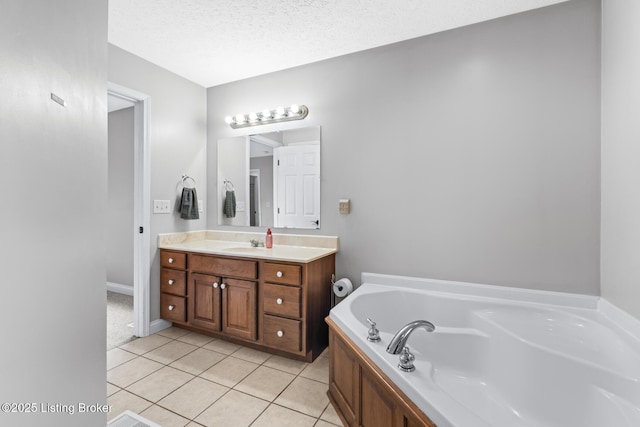 bathroom featuring vanity, a tub to relax in, tile patterned flooring, and a textured ceiling