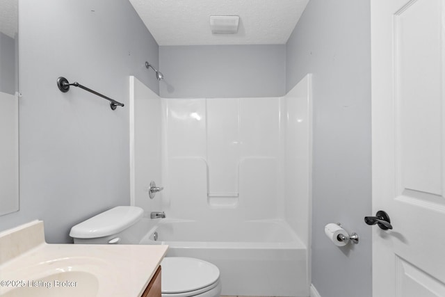 full bathroom with vanity,  shower combination, toilet, and a textured ceiling