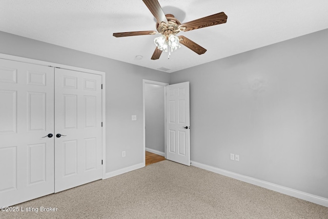 unfurnished bedroom with carpet floors, ceiling fan, and a closet