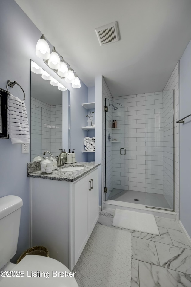 bathroom with a shower with door, vanity, and toilet