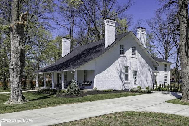 view of side of property featuring a yard and covered porch