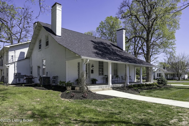 view of front of home featuring a porch, central AC unit, and a front lawn