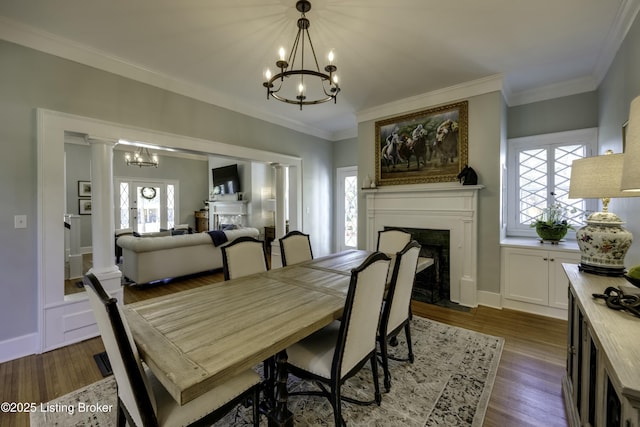 dining space with hardwood / wood-style flooring, crown molding, a wealth of natural light, and a notable chandelier