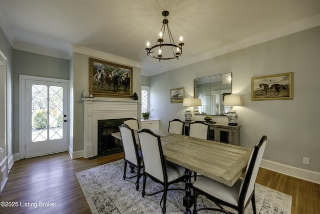 dining space featuring wood-type flooring, ornamental molding, and a notable chandelier